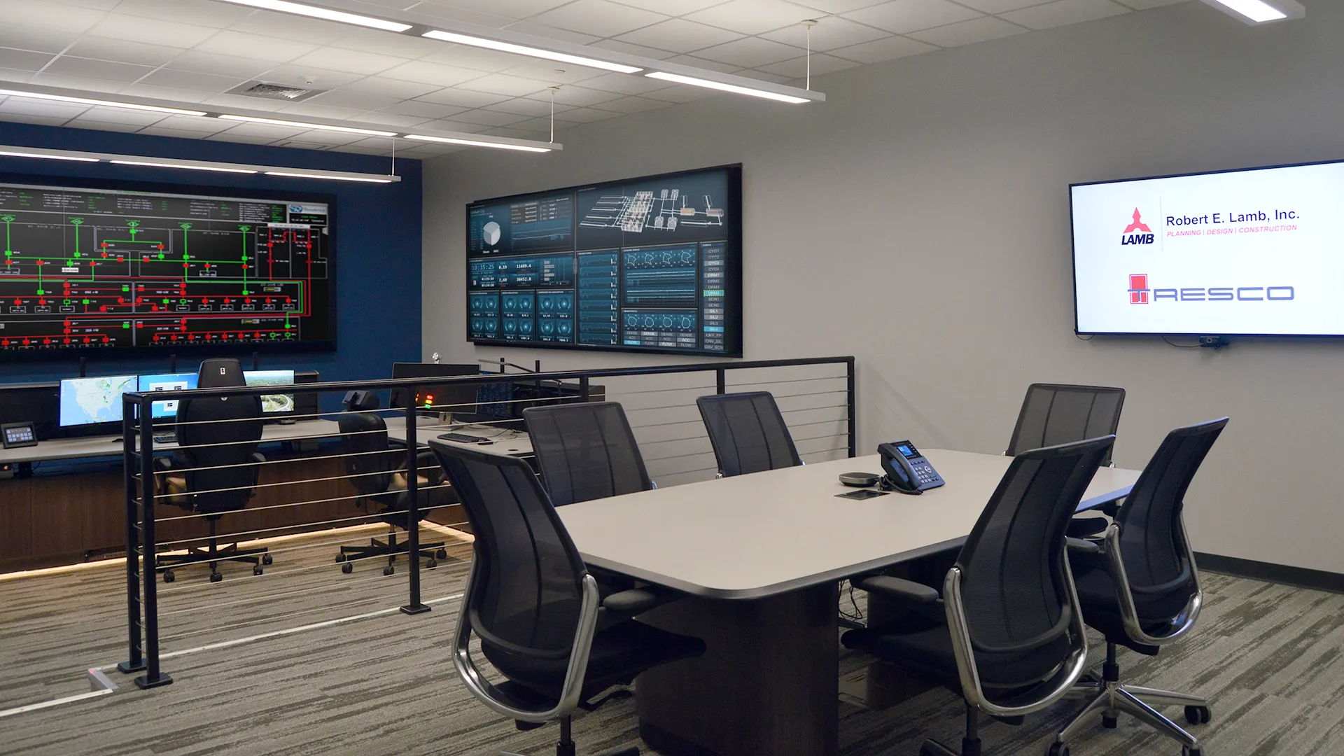 Tresco control room consoles featured in one of Robert E. Lamb's showrooms with a conference table for collaborative work